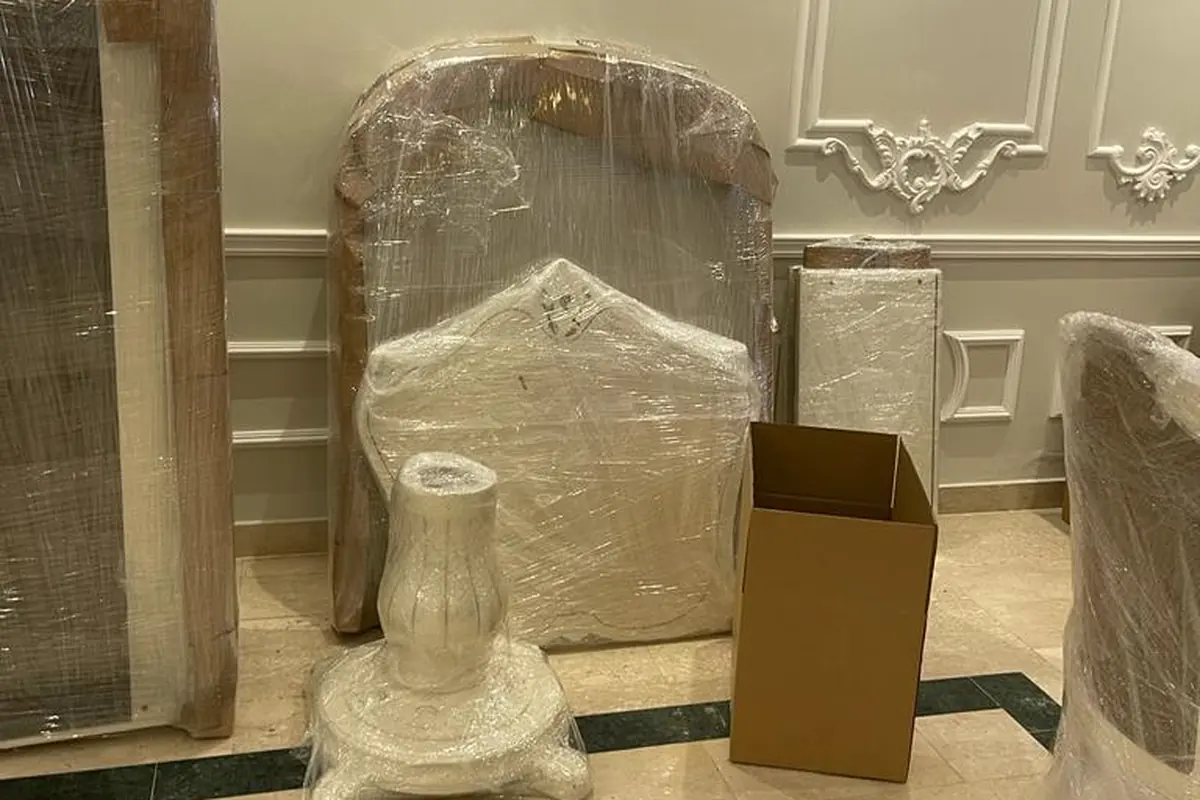 أجزاء غرفة نوم مفككة ومغلفة مع كراتين التعبئة — خبراء الإنجاز