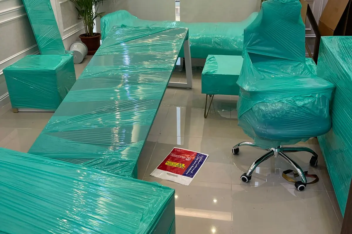 مكتب وكرسي مغلفان في غرفة إدارة قبل النقل — خبراء الإنجاز