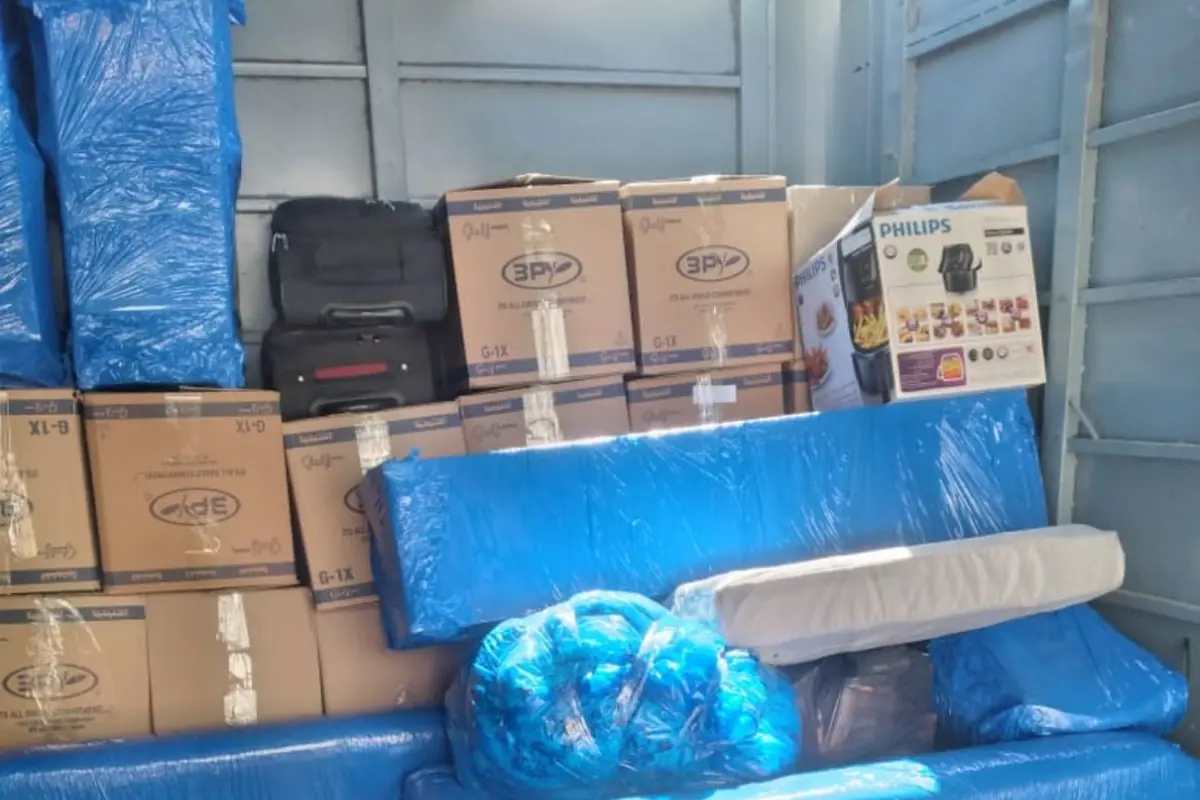 كنب وكراتين وأجهزة مغلفة ومرتبة داخل سيارة النقل