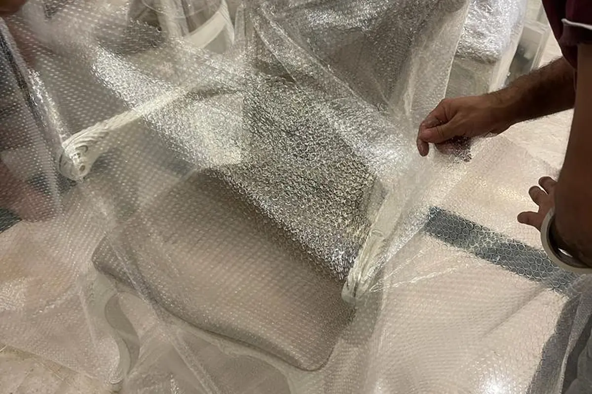 تغليف كرسي بالنايلون الشفاف أثناء التجهيز للنقل — خبراء الإنجاز